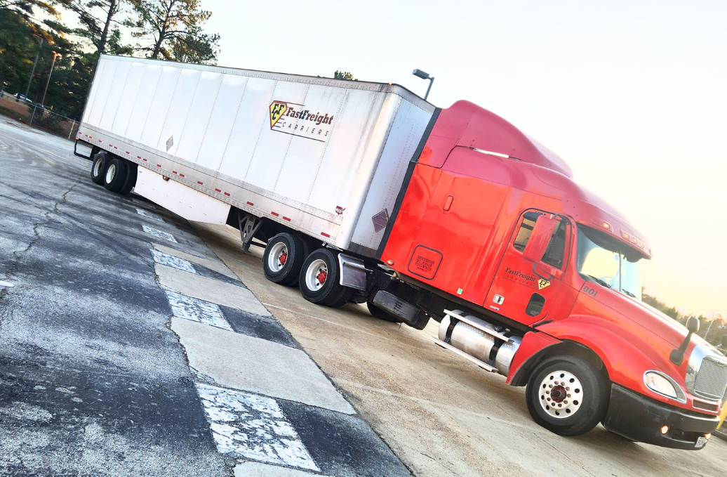 Side view of a Fast Freight Carriers truck parked in a lot
